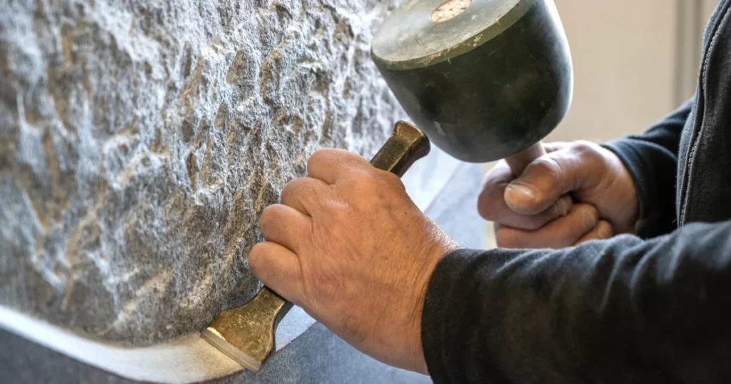 Steinmetz bei seiner Arbeit, bearbeiten eines Steins. Stonage Liebig aus Flüelen, Uri